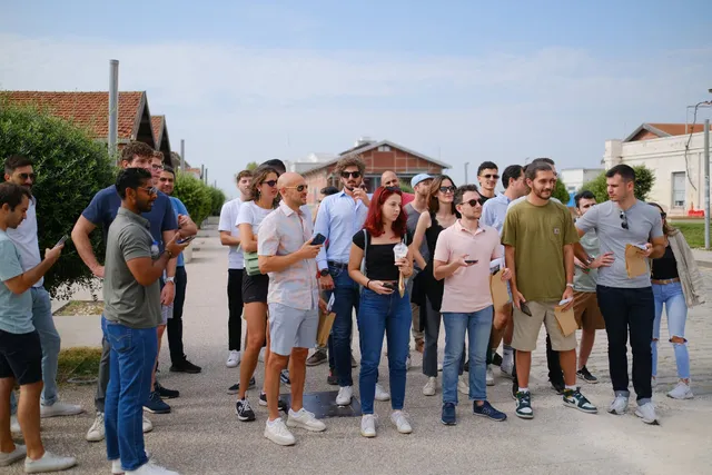 Colleagues with envelopes and phones at the start of a city treasure hunt by the old port warehouses in Thessaloniki