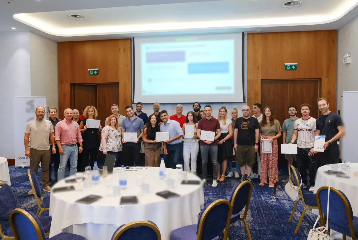 A corporate team holding up their drawings after a team building workshop in a hotel conference room in Thessaloniki