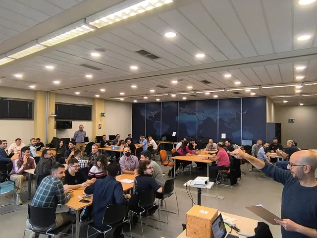 A Salty Soil facilitator runs a team challenge for a large group seated at tables in a company training room