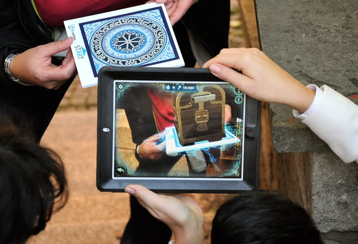 Players point a tablet at a game card and an augmented-reality treasure chest appears on screen in Magic Portal, a Salty Soil family AR escape game