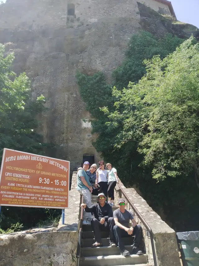 A group of guests on the steps at the entrance of the Great Meteoron monastery on a Salty Soil day trip from Thessaloniki
