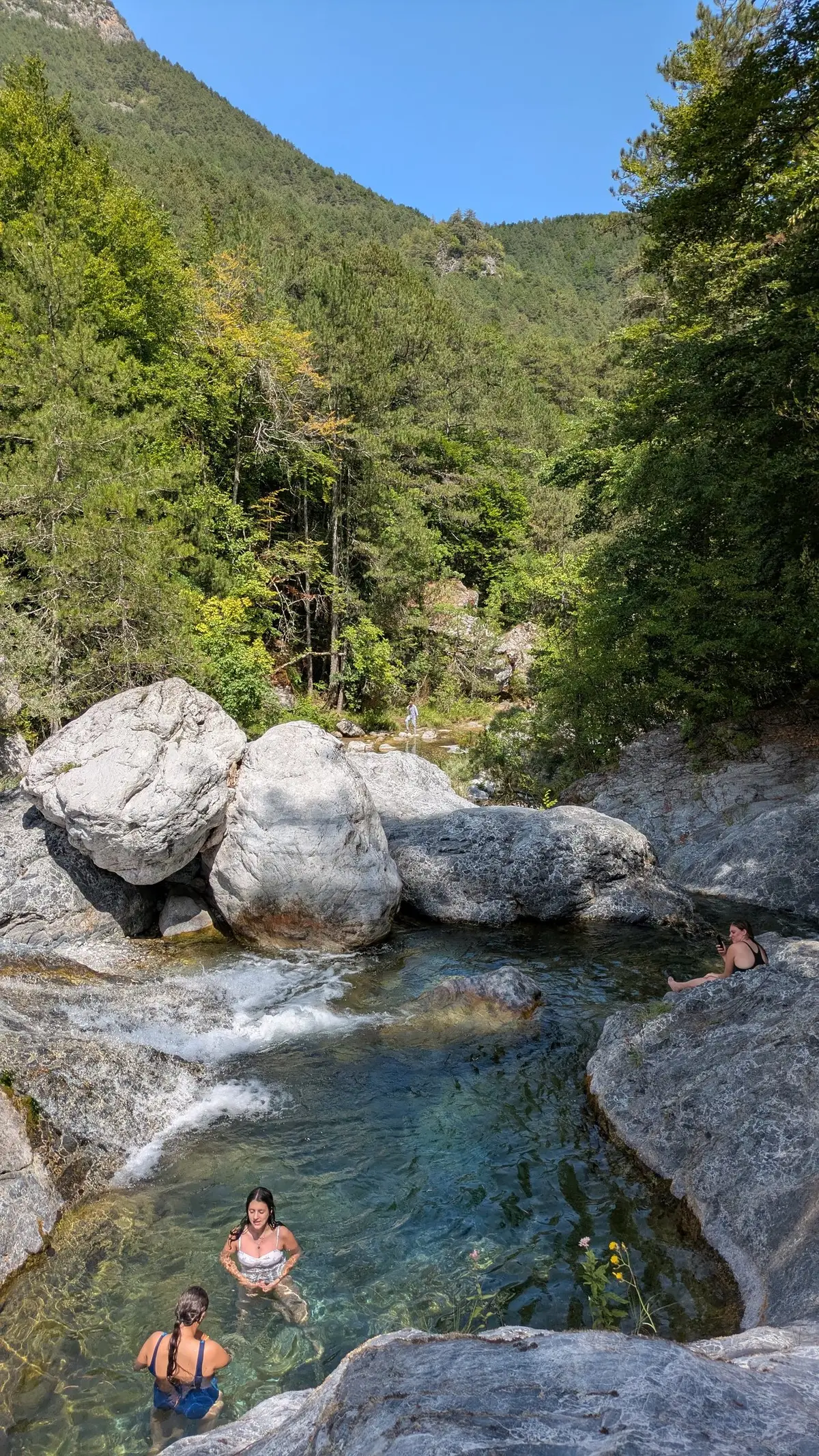 Guests swim in clear natural rock pools on the trail to the cave of Agios Dionysios on Mount Olympus, on a Salty Soil day trip from Thessaloniki