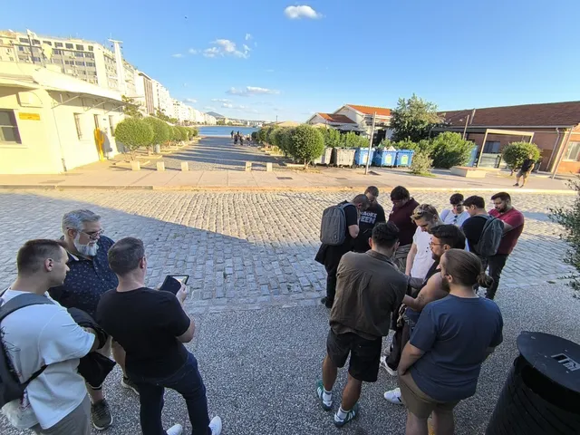 Δύο ομάδες μελετούν τα tablet τους σε σημείο ελέγχου δίπλα στο λιμάνι της Θεσσαλονίκης κατά τη διάρκεια του Operation Mindfall, ενός AR escape game της Salty Soil.