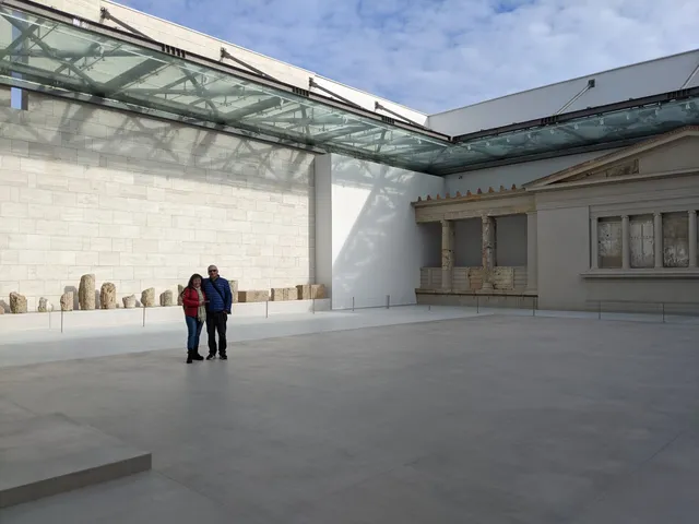 Two guests in the open courtyard of the Museum of Aigai at Vergina, beside the reconstructed palace façade, on a Salty Soil private multi-day tour