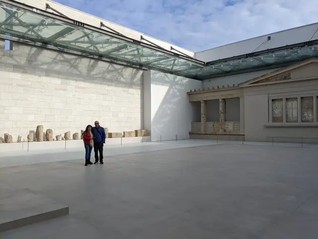 Two guests in the open courtyard of the Museum of Aigai at Vergina, beside the reconstructed palace façade, on a Salty Soil private multi-day tour