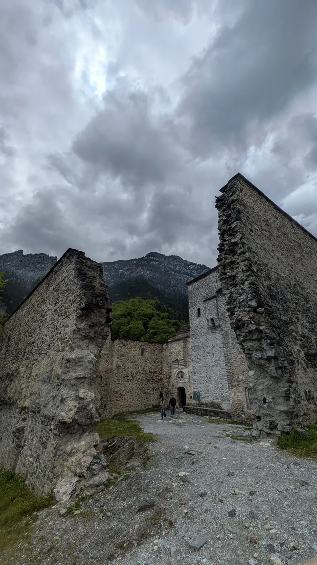 Visitors walk into the Old Monastery of Agios Dionysios below the forested slopes of Mount Olympus, on a Salty Soil private multi-day tour