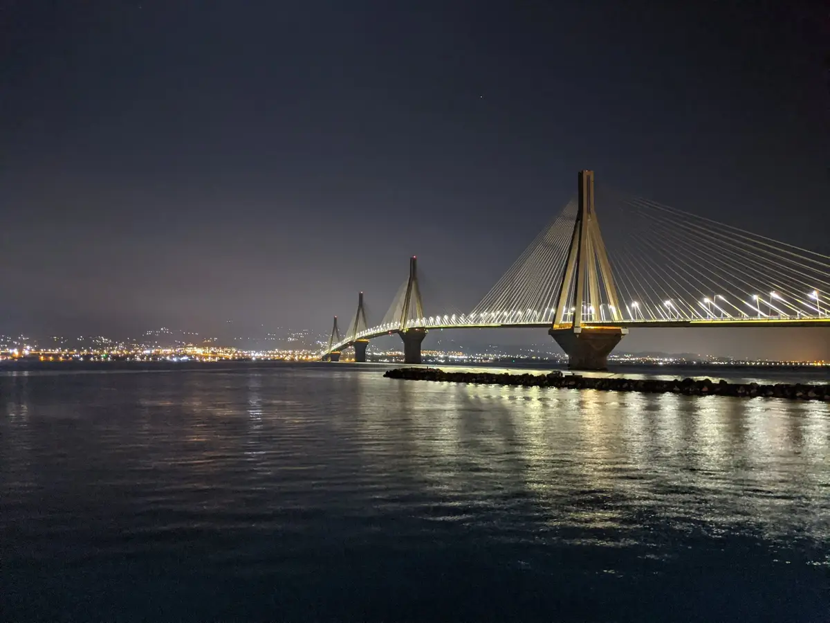 The Rio–Antirrio bridge lit up at night over the Gulf of Corinth, seen on a Salty Soil private multi-day tour of Greece