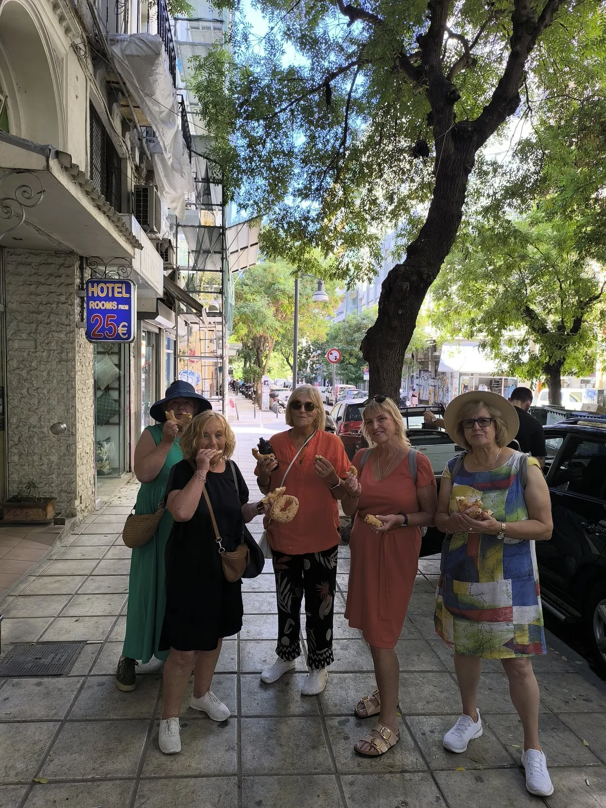 Πέντε επισκέπτες δοκιμάζουν φρέσκα κουλούρια με σουσάμι σε δρόμο της Θεσσαλονίκης, σε γαστρονομική περιήγηση της Salty Soil