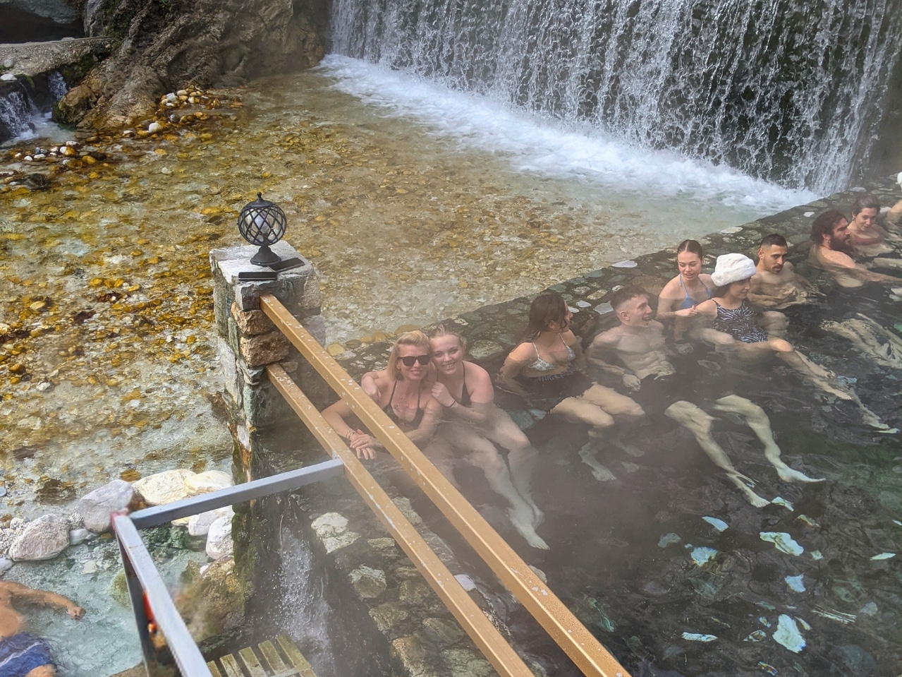 Visitors relaxing in the outdoor thermal baths of Pozar during a day trip from Thessaloniki with Salty Soil